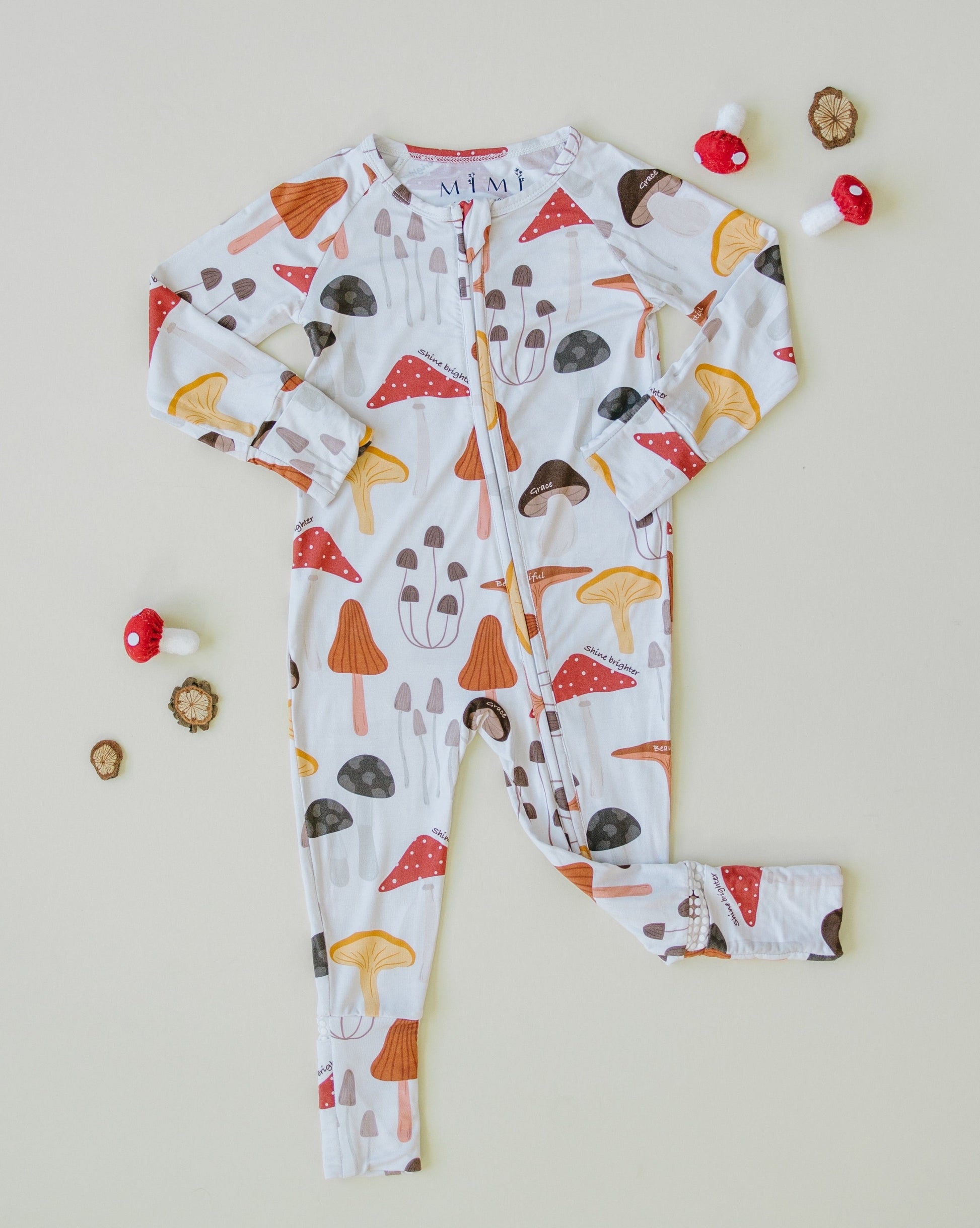 Flat Lay Little sleepies baby bamboo pajamas with mushroom print and words of affirmation for kids and mothers.